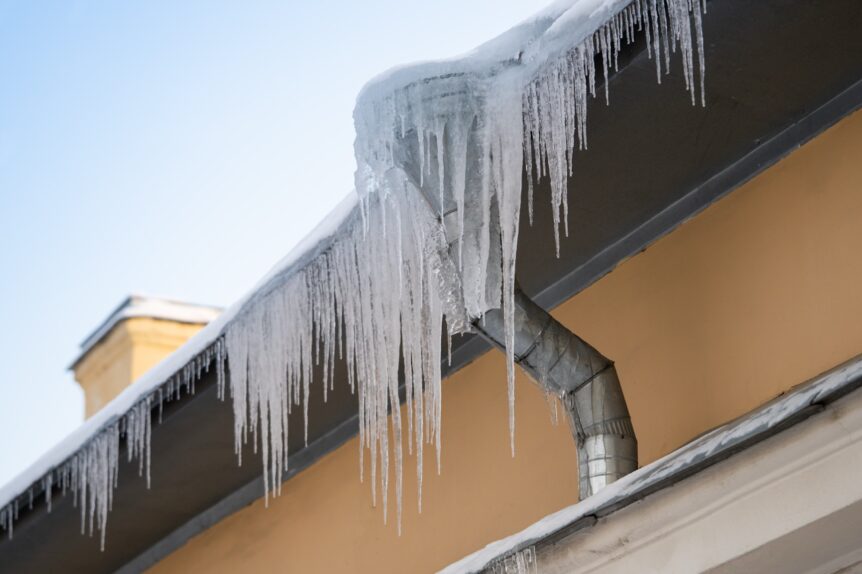 Large frozen icicles hanging dangerously from a building.